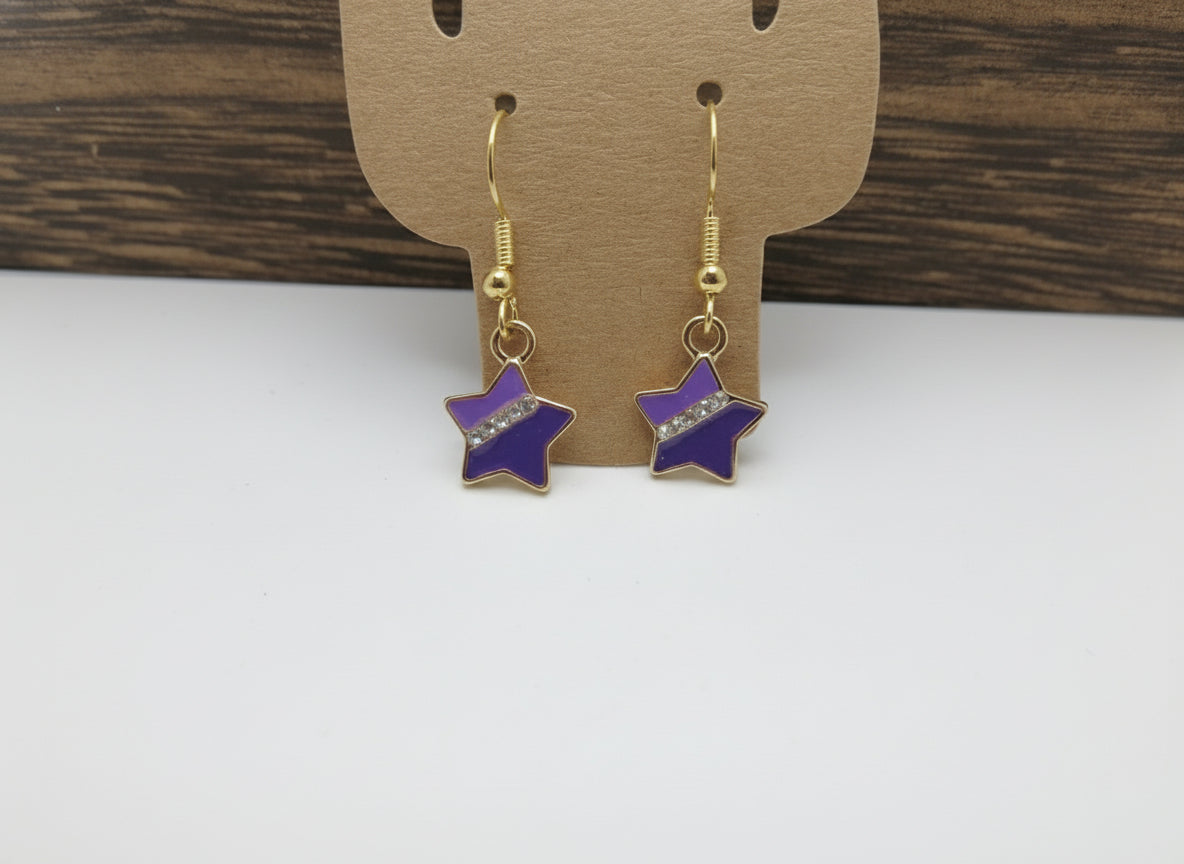 Star-shaped earrings on a brown card with a wooden background
