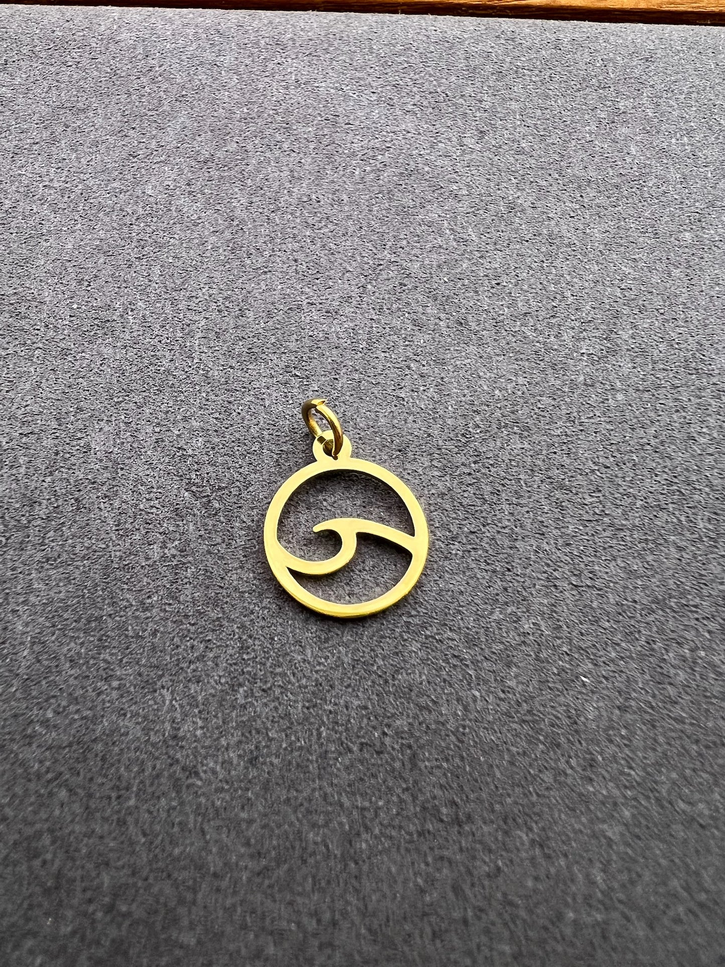 Gold pendant on a gray textured surface
